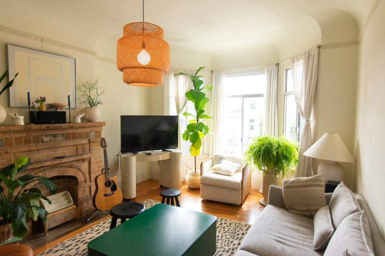 Furnished living room with bay windows, brick fireplace, and wood-style flooring.