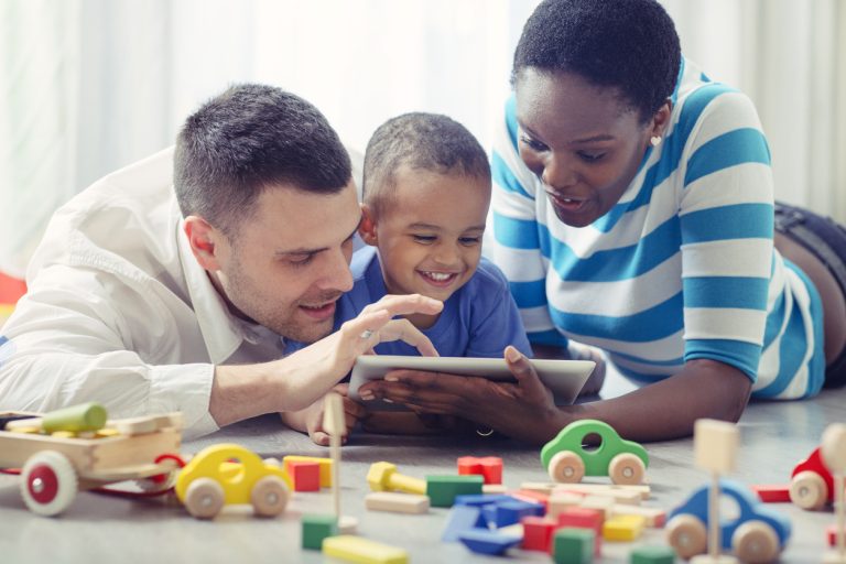 Multi-ethnic Family with one child having fun with digital tablet.