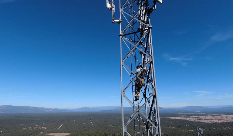 Maintenance technician on an Intermax Networks tower overlooking Northern Idaho.