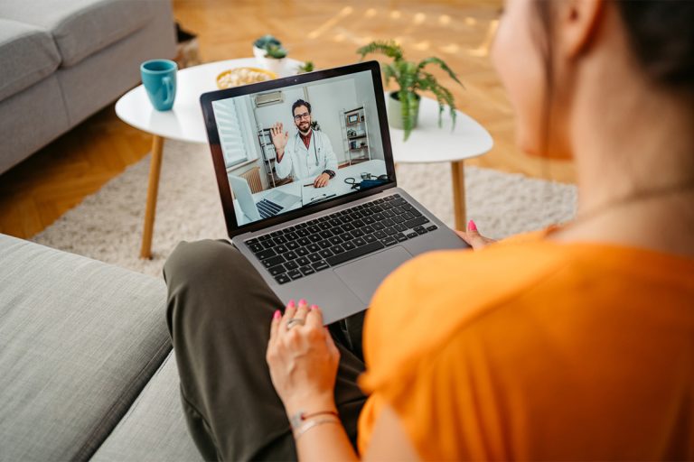 Woman having a doctor's appointment online over the laptop, while sitting at home.