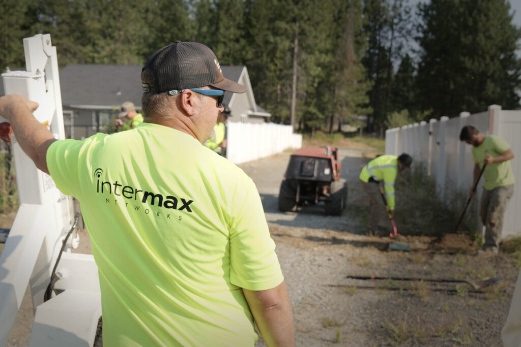 Underground fiber cable installation with workers in the background.