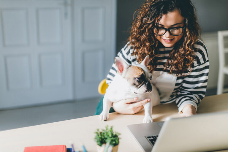 Woman with dog working in a home office.
