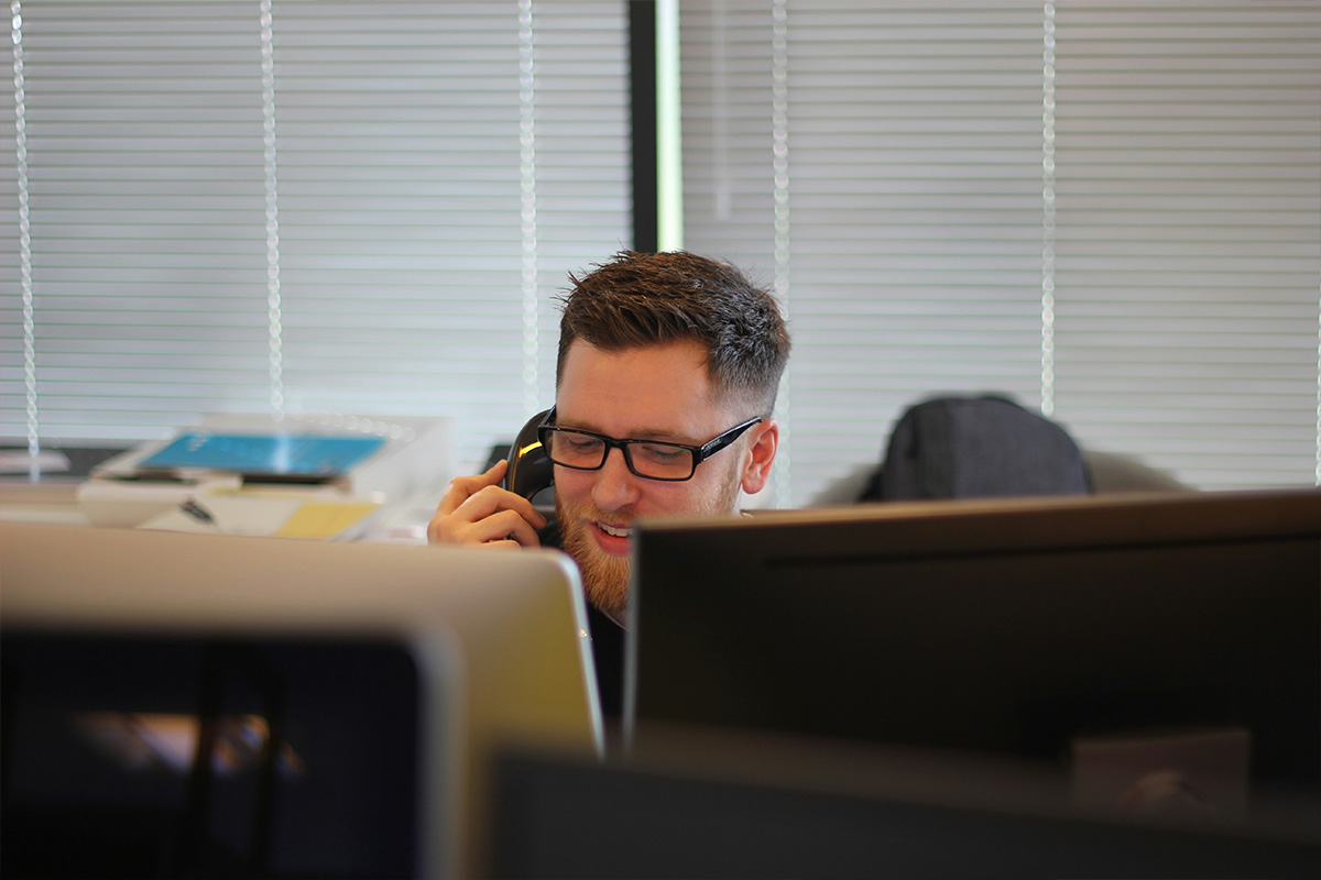 man using IP phone inside room. Photo by Berkeley Communications on Unsplash
