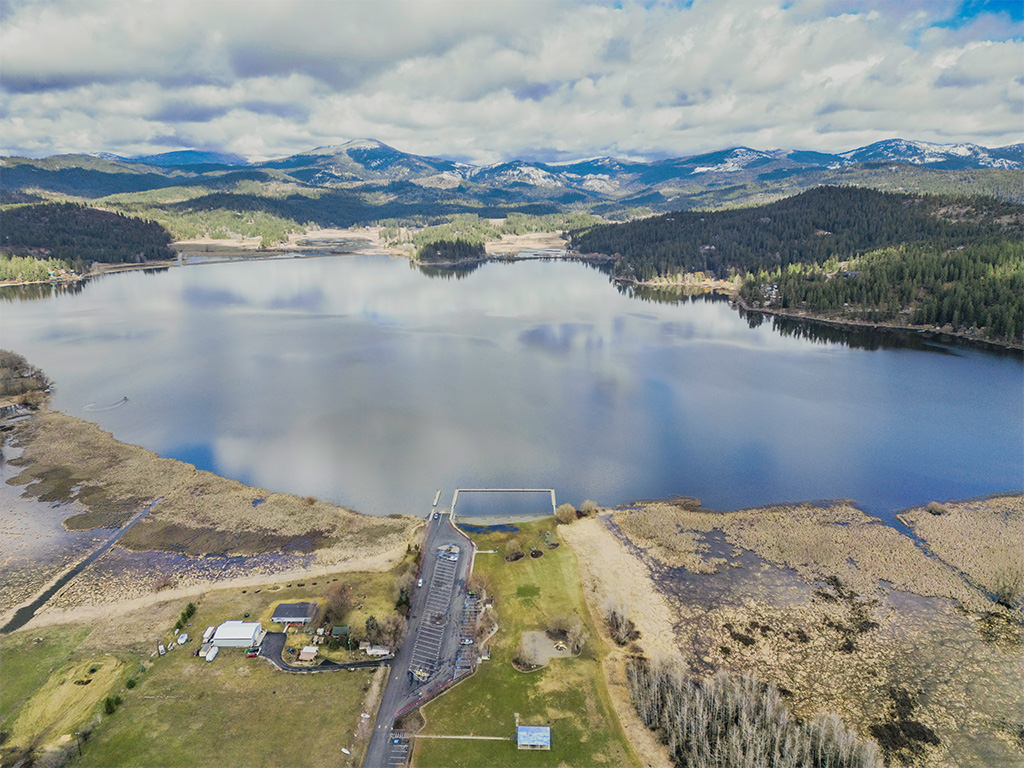 Aerial view of Hauser Lake with mountains in the distance.
