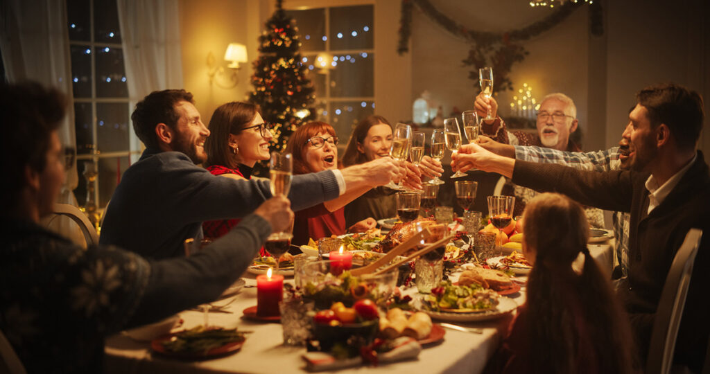 Family and Friends Sharing Meals, Raising Glasses with Champagne, Toasting, Celebrating a Winter Holiday