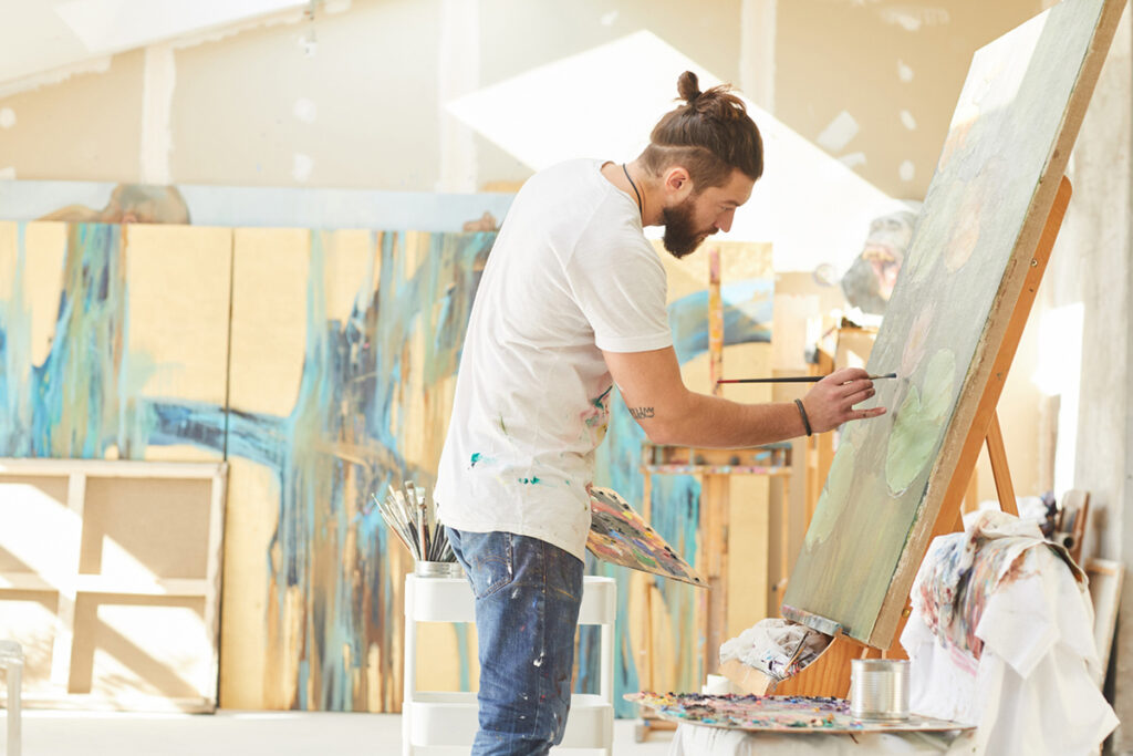 Man painting on a canvas.