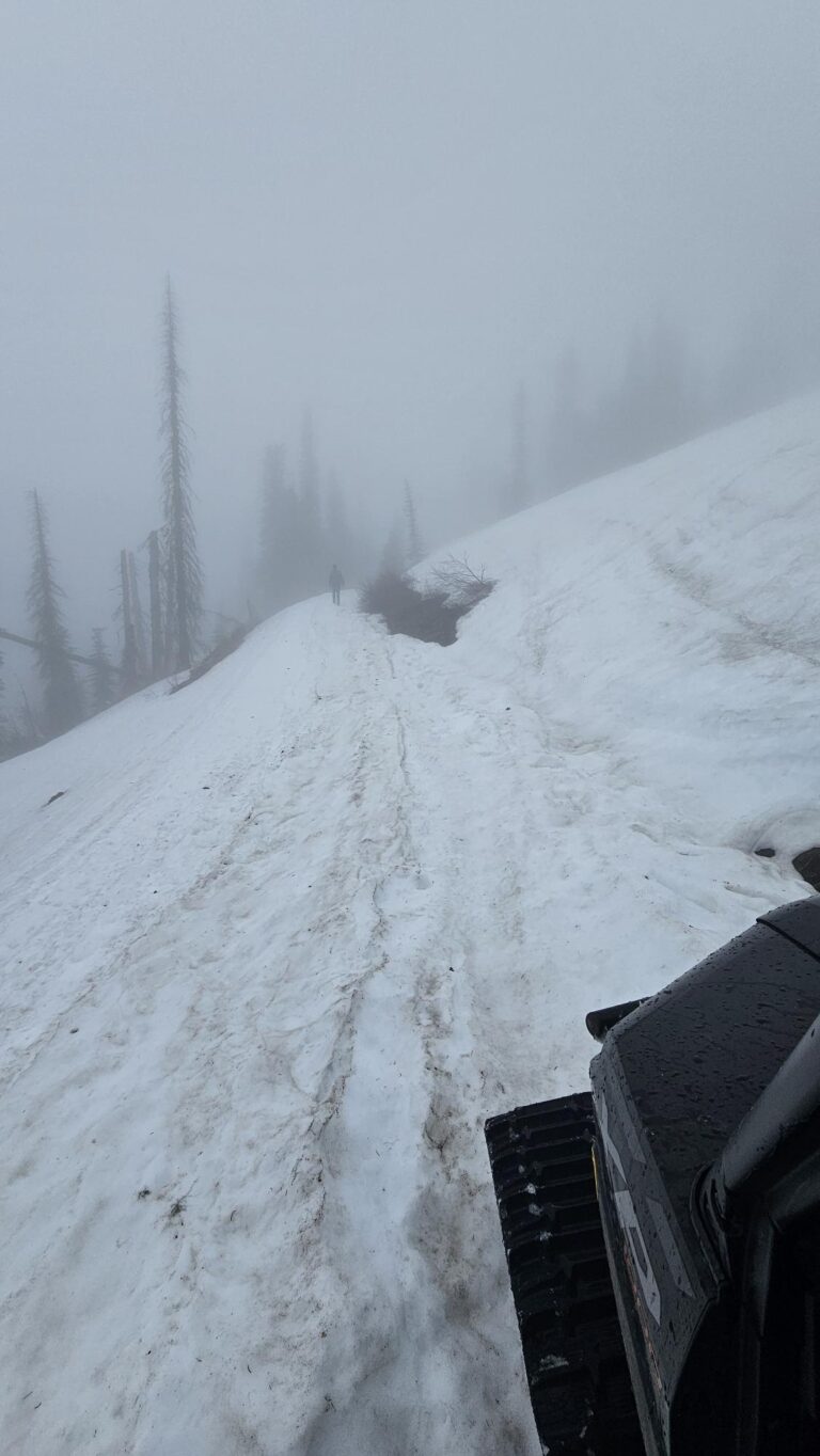 Intermax tech on a snowy mountain with low visibility.