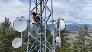 Intermax fixed wireless tech in a tower surrounded my treetops and mountains in the distance.