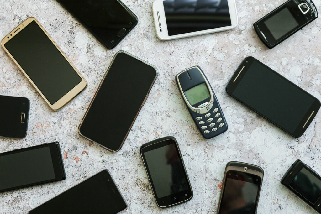 A collection of cell phones from Nokia brick to smartphones.