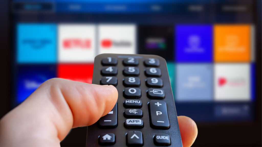 Close up of remote with streaming apps in the backgound.
