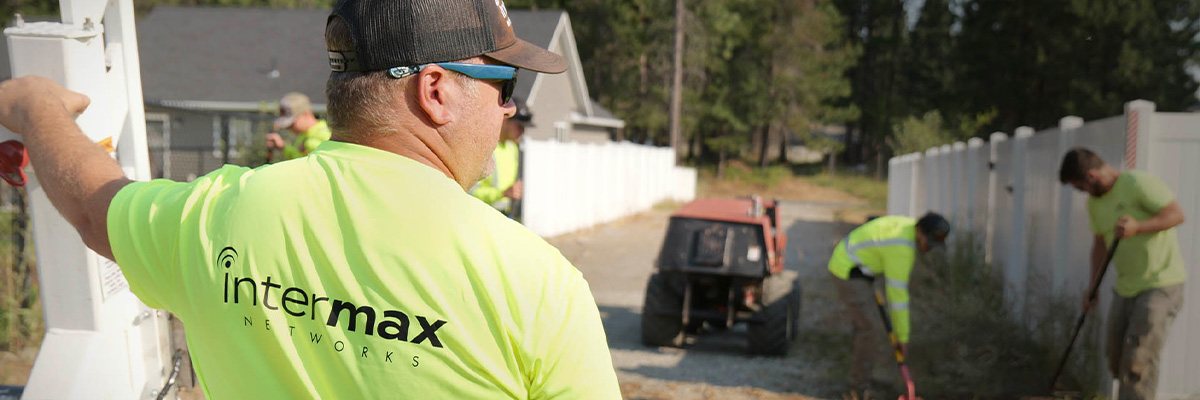 Underground fiber cable installation with workers in the background.