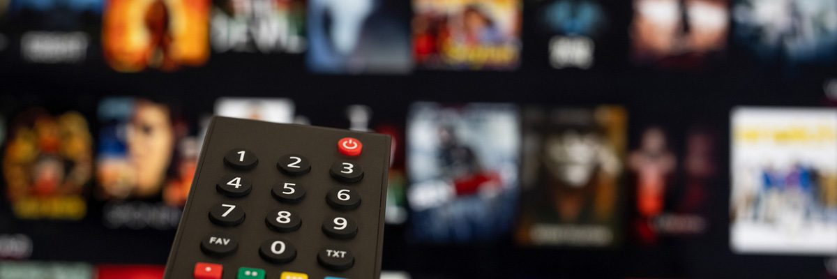 A woman's hand holding a tv remote.
