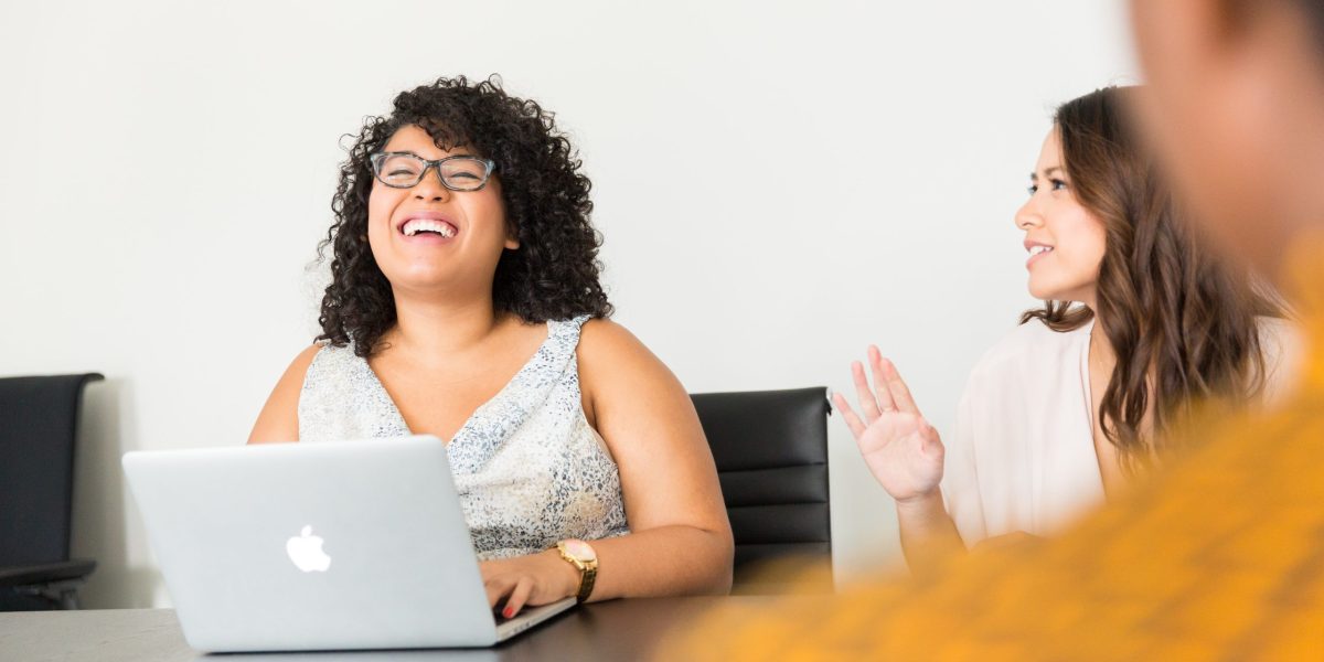 Business people work on wireless laptops during meeting