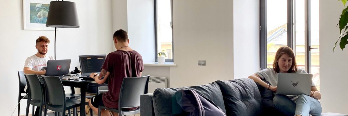 Three people sitting around each other working on their laptops.