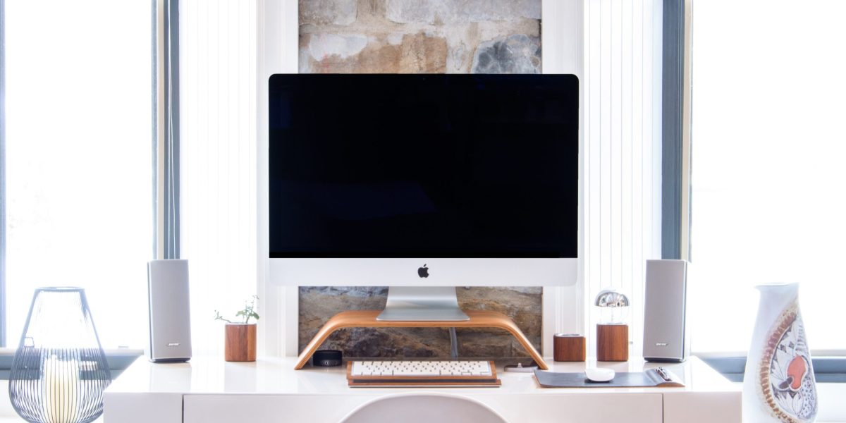Computer monitor sitting on desk with keyboard and other devices