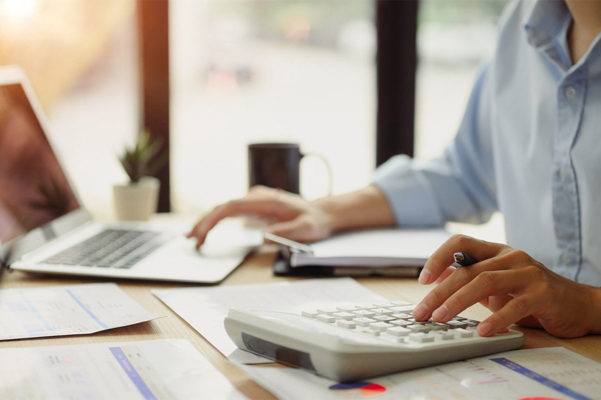 intermax-5-reasons-to-bundle-services-1 Business person budgeting with calculator and laptop.