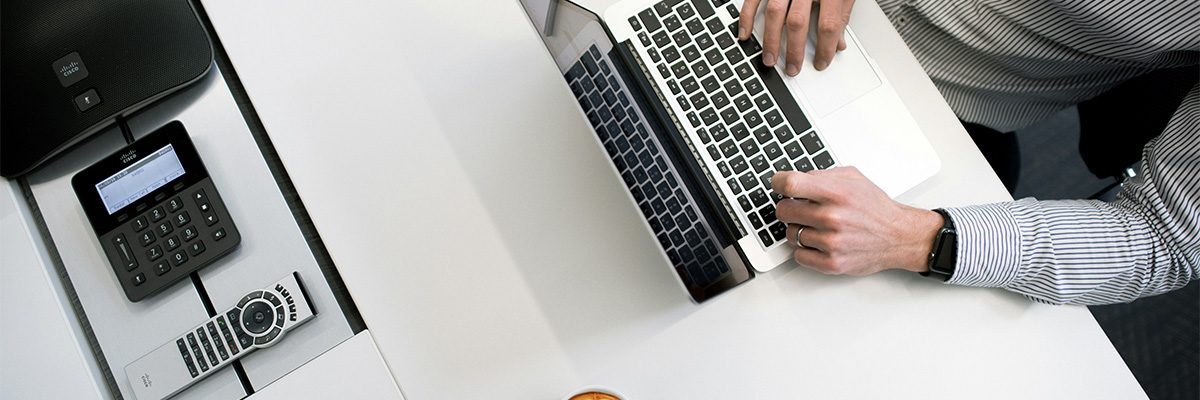 Person using laptop on white wooden table. Photo by Tyler Franta on Unsplash