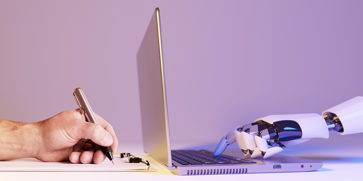 Human hand writing and robot hand using a laptop.