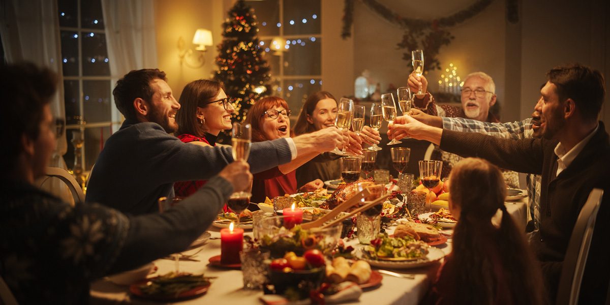 Family and Friends Sharing Meals, Raising Glasses with Champagne, Toasting, Celebrating a Winter Holiday