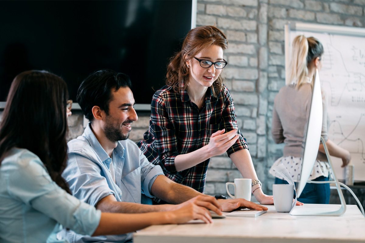 IT professionals working with laptop and tablet in data center, monitoring network systems.
