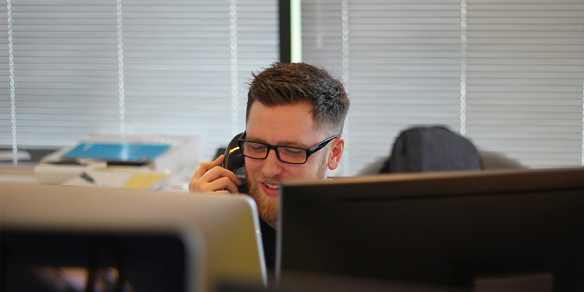 man using IP phone inside room. Photo by Berkeley Communications on Unsplash