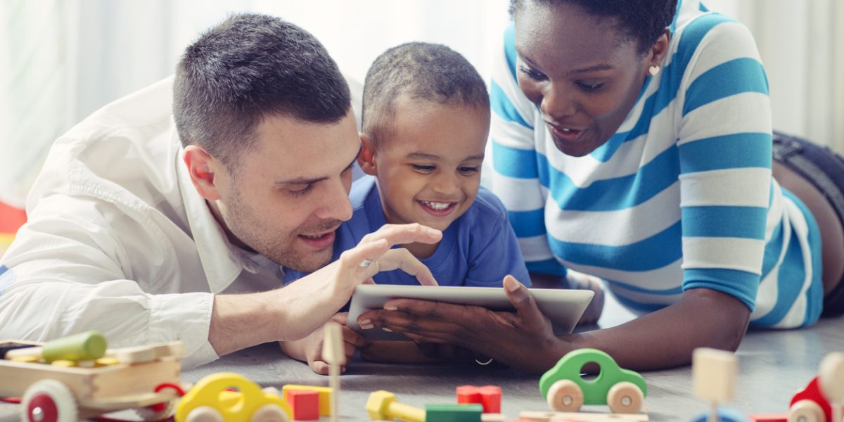 Multi-ethnic Family with one child having fun with digital tablet.