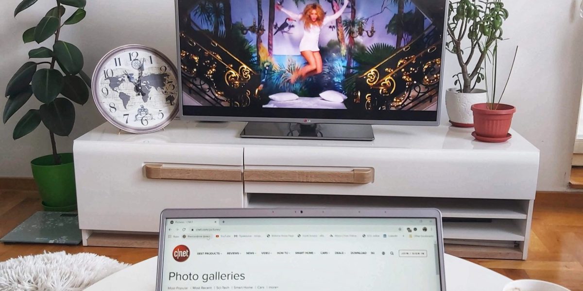 Laptop sits on table in front of TV