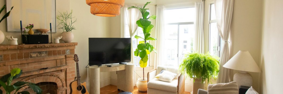 Furnished living room with bay windows, brick fireplace, and wood-style flooring.
